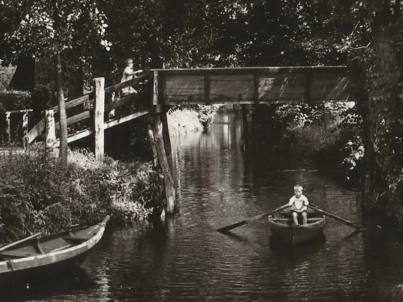 Jongetje is aan het roeien in de Dorpsgracht.